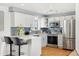 Modern kitchen with stainless steel appliances, quartz countertops, and peninsula seating at 10699 W 9Th Pl, Lakewood, CO 80215