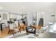 Open-concept living area with a view of the kitchen, featuring hardwood floors and stylish furniture at 10699 W 9Th Pl, Lakewood, CO 80215