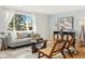 Cozy living room with large windows, hardwood floors, and modern furniture at 10699 W 9Th Pl, Lakewood, CO 80215