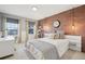 Modern bedroom with brick accent wall and a desk area at 9554 Queenscliffe Dr, Highlands Ranch, CO 80130