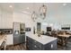 Open-concept kitchen with island and stainless-steel refrigerator with views of the dining room and living space at 2640 S Orchard St, Lakewood, CO 80228