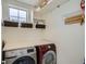 Efficient laundry room with front-loading washer/dryer, a folding counter, and built-in shelving at 2640 S Orchard St, Lakewood, CO 80228