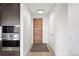 Hallway features a wood front door, wood floors, and modern lighting fixtures at 155 Steele St # 414, Denver, CO 80206