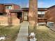 Exterior view of townhome with brick accents and a walkway leading to the entrance at 2685 S Dayton Way # 74, Denver, CO 80231