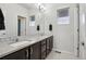 Bright bathroom with double sinks, large mirror, modern fixtures, and decorative backsplash at 12233 Hannibal St, Commerce City, CO 80603