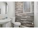 Stylish half-bathroom with modern sink, toilet, and wood-look accent wall at 12233 Hannibal St, Commerce City, CO 80603