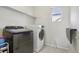 Well-lit laundry room featuring modern washer and dryer with a folding table at 12233 Hannibal St, Commerce City, CO 80603