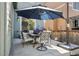 Outdoor patio with seating under a large umbrella, a barbeque, and views of the lush green backyard at 12233 Hannibal St, Commerce City, CO 80603