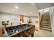 Finished basement with foosball table, desk, and exercise equipment at 1210 Snowberry Ln, Broomfield, CO 80020