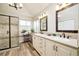 Spacious bathroom with double vanity, tiled shower, and wood-look floors at 1210 Snowberry Ln, Broomfield, CO 80020