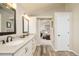 Bathroom showcasing double vanity, wood flooring, and bedroom entrance at 1210 Snowberry Ln, Broomfield, CO 80020