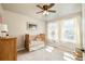 Bright bedroom featuring a crib, dresser and two windows at 1210 Snowberry Ln, Broomfield, CO 80020