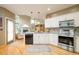 Modern kitchen with stainless steel appliances, white cabinets, granite countertops, and hardwood floors at 1210 Snowberry Ln, Broomfield, CO 80020