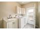Functional laundry room with washer, dryer, sink, and storage cabinets at 1210 Snowberry Ln, Broomfield, CO 80020