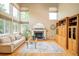 Bright living room with fireplace, hardwood floors, large windows, and stylish furniture at 1210 Snowberry Ln, Broomfield, CO 80020