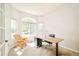 Bright home office with a wooden desk, comfortable chair, and large windows at 1210 Snowberry Ln, Broomfield, CO 80020