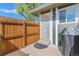 Cozy fenced-in patio with green siding, offering a private outdoor space with a covered grill and a screen door at 9901 E Evans Ave # 9A, Aurora, CO 80247