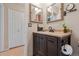 Bathroom featuring a single vanity, two mirrors, a toilet paper holder, and wood look flooring at 9901 E Evans Ave # 9A, Aurora, CO 80247