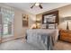 Neutral bedroom with a large bed, framed mirror, ceiling fan, and a window with great natural light at 9901 E Evans Ave # 9A, Aurora, CO 80247