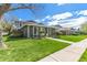 Lawn view of the exterior of single-story home featuring green siding and a manicured lawn at 9901 E Evans Ave # 9A, Aurora, CO 80247