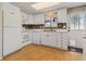 Functional kitchen featuring white appliances, lots of cabinet space, and natural light at 9901 E Evans Ave # 9A, Aurora, CO 80247