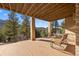 A large back porch with stacked stone columns overlooks a natural area at 21016 Horse Bit Way, Morrison, CO 80465
