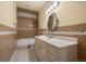 Bathroom featuring tiled shower and backsplash, decorative mirror and sconces, and a neutral vanity at 21016 Horse Bit Way, Morrison, CO 80465