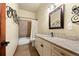 Bathroom with granite countertops, modern fixtures, decorative mirror, and tiled shower and flooring at 21016 Horse Bit Way, Morrison, CO 80465