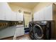 Bright laundry room featuring ample cabinet space, modern washer and dryer, and a convenient utility sink at 21016 Horse Bit Way, Morrison, CO 80465