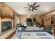 Comfortable living room with stone fireplace, ceiling fan and plush area rug at 21016 Horse Bit Way, Morrison, CO 80465
