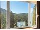 Scenic window view showcasing the lush green forest and surrounding mountains on a clear day at 21016 Horse Bit Way, Morrison, CO 80465