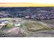 Panoramic aerial shot of a community with a playground, expansive fields, and a stunning sunset backdrop at 2144 Rosette Ln, Castle Rock, CO 80104