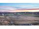Community aerial view featuring residences nestled amidst natural landscapes and a vibrant sunset horizon at 2144 Rosette Ln, Castle Rock, CO 80104