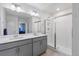 Bright bathroom featuring a double sink vanity, a glass shower and tiled floors at 2144 Rosette Ln, Castle Rock, CO 80104