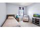 Cozy bedroom with a twin bed, a window, a patterned armchair and carpeted floors at 2144 Rosette Ln, Castle Rock, CO 80104