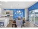 Inviting dining area with a large table, blue accent wall, and sliding glass doors leading to an outdoor space at 2144 Rosette Ln, Castle Rock, CO 80104
