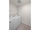 Clean laundry room featuring a modern white washer and dryer set and tiled floors at 2144 Rosette Ln, Castle Rock, CO 80104