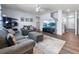 Bright living room featuring a comfortable sofa, decorative shelving, and a view into the entry and stairs at 2144 Rosette Ln, Castle Rock, CO 80104