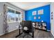 Cozy office space with a large window, hardwood flooring, and a blue accent wall at 2144 Rosette Ln, Castle Rock, CO 80104