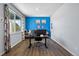 Home office with large window, blue accent wall, sleek desk, and modern decor for a comfortable work environment at 2144 Rosette Ln, Castle Rock, CO 80104