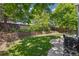 Serene backyard featuring a tiered brick retaining wall, lush lawn, and mature trees providing ample shade at 13439 Antlers St, Broomfield, CO 80020