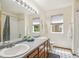 A well-lit bathroom featuring dual sinks, tile floors and a shower and bathtub combination at 13439 Antlers St, Broomfield, CO 80020