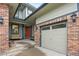 Inviting front porch featuring a porch swing, brickwork, and an adjacent two-car garage at 13250 Wild Basin Way, Broomfield, CO 80020