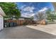 Large concrete driveway leading to a backyard with full fence and mature tree at 11957 Claude Ct, Northglenn, CO 80233