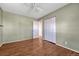 A bright bedroom offers durable wood-look floors, neutral wall paint, closet space, and bright light at 11957 Claude Ct, Northglenn, CO 80233