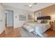 Bright primary bedroom featuring hard wood floors, artwork, and a seating bench at 11957 Claude Ct, Northglenn, CO 80233