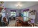 Charming bedroom featuring a wooden table with stools, a stylish chandelier, and two sunlit windows at 10640 W 46Th Ave, Wheat Ridge, CO 80033