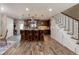 Open kitchen featuring an island with barstool seating, stainless appliances, and wood-look flooring at 10640 W 46Th Ave, Wheat Ridge, CO 80033