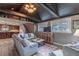 Cozy living room with exposed beams, fireplace, large windows, and open layout to the kitchen at 10640 W 46Th Ave, Wheat Ridge, CO 80033