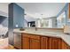 Spacious kitchen featuring wood cabinets, stone countertops, and stainless steel dishwasher at 9917 Grove Way # A, Westminster, CO 80031
